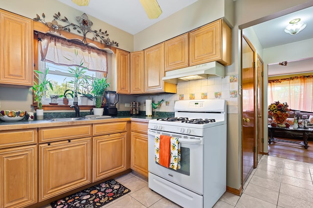 kitchen featuring plenty of natural light, light tile patterned floors, and gas range gas stove