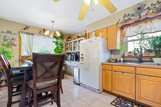 kitchen with light tile patterned flooring, a healthy amount of sunlight, white fridge with ice dispenser, and sink