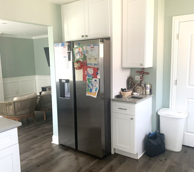 kitchen featuring dark hardwood / wood-style floors, white cabinets, stainless steel fridge, and ornamental molding