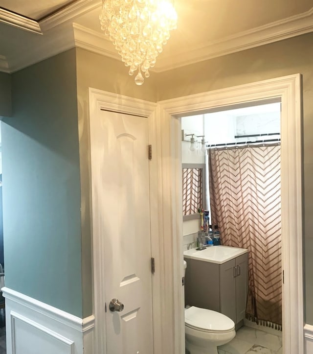 bathroom featuring a notable chandelier, crown molding, toilet, and vanity