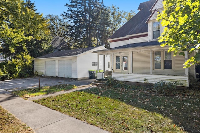 view of front facade featuring an outdoor structure, a garage, and a front lawn