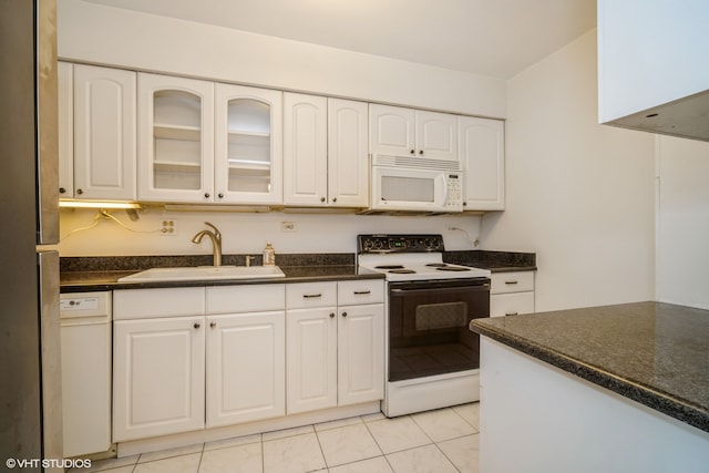 kitchen with light tile patterned floors, sink, white appliances, and white cabinetry