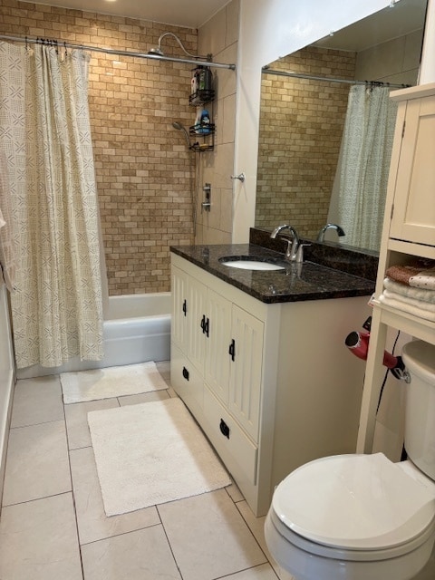 full bathroom with shower / tub combo, tile patterned flooring, vanity, and toilet