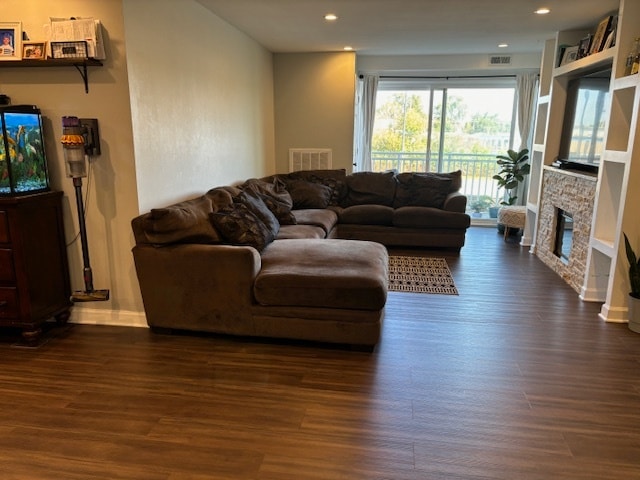 living room with a fireplace and dark hardwood / wood-style flooring