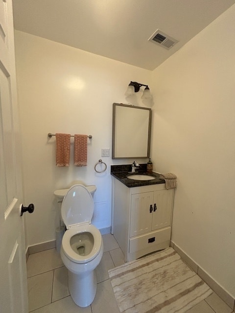 bathroom with vanity, toilet, and tile patterned floors