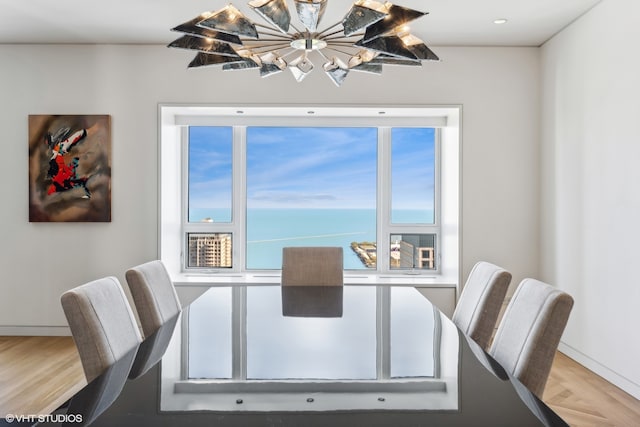 dining area featuring a water view and hardwood / wood-style flooring