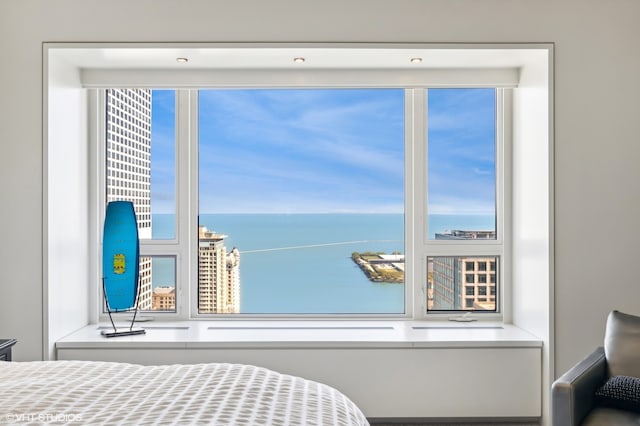 bedroom with multiple windows and a water view