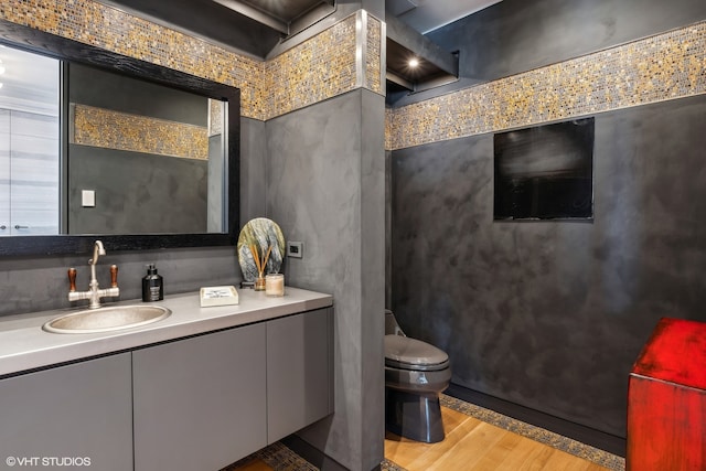 bathroom featuring vanity, wood-type flooring, and toilet