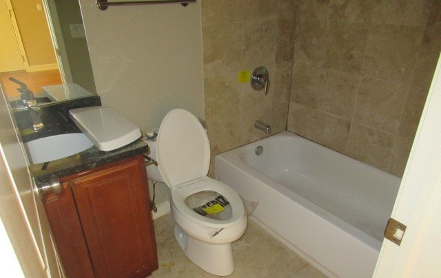 full bathroom with tiled shower / bath, vanity, toilet, and tile patterned floors