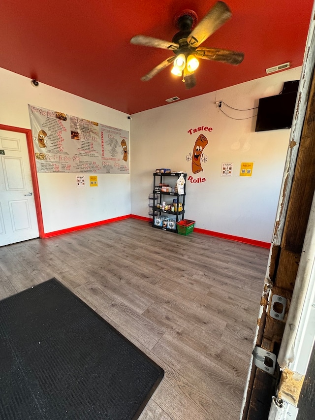 misc room with wood-type flooring and ceiling fan