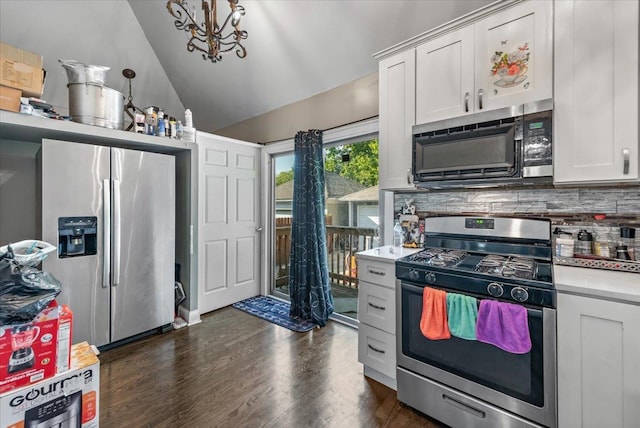 kitchen featuring white cabinetry, appliances with stainless steel finishes, light countertops, lofted ceiling, and decorative backsplash