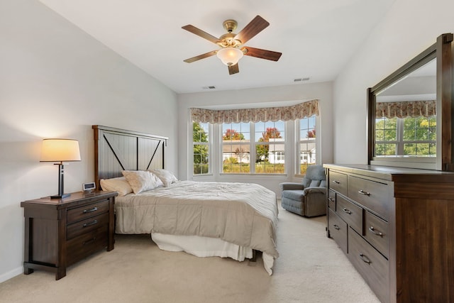 bedroom with multiple windows, ceiling fan, and light colored carpet