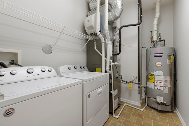 clothes washing area featuring washing machine and dryer and water heater