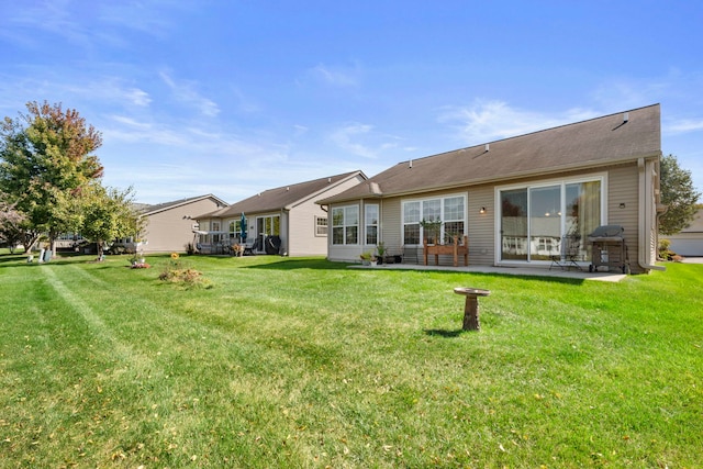 back of property with a yard and a patio area