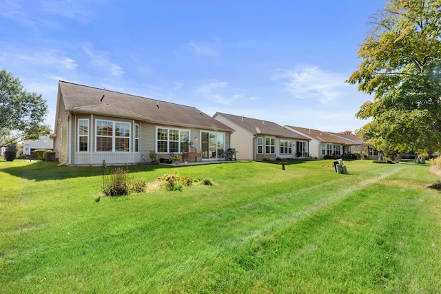 rear view of property featuring a lawn