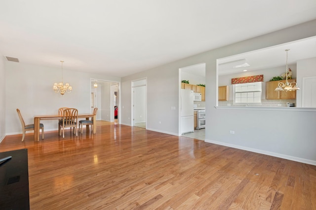 interior space with an inviting chandelier and light hardwood / wood-style floors