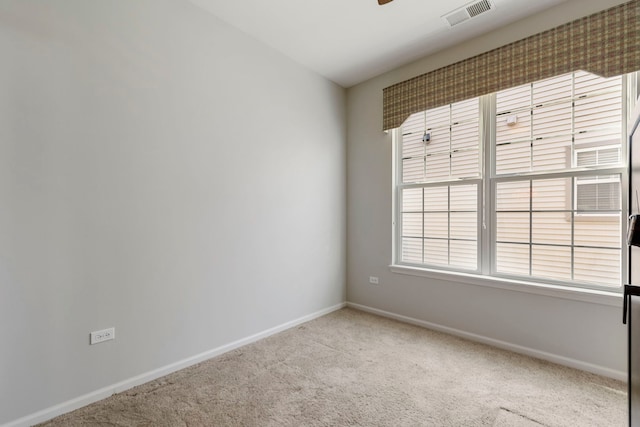 carpeted spare room with ceiling fan