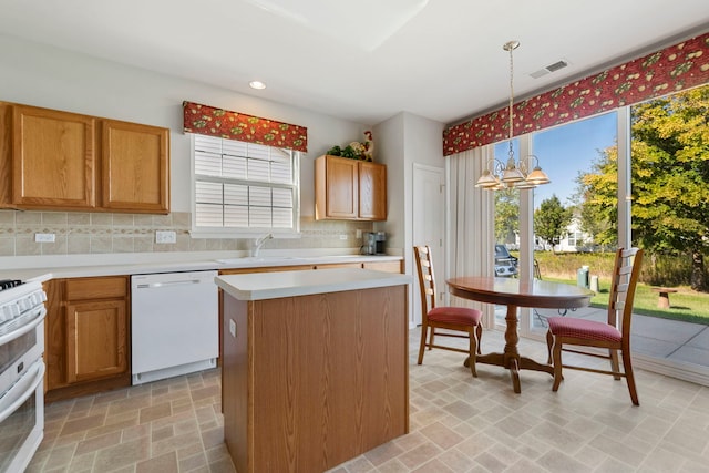 kitchen with a chandelier, tasteful backsplash, white appliances, decorative light fixtures, and a center island