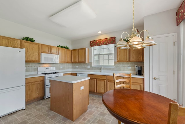 kitchen with white appliances, a notable chandelier, sink, hanging light fixtures, and a center island