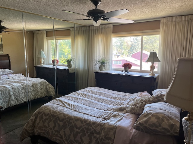 bedroom with multiple windows, a textured ceiling, and ceiling fan