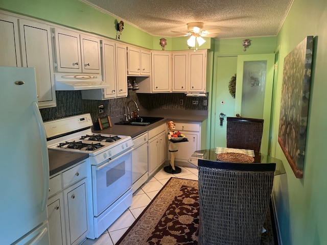 kitchen with ceiling fan, backsplash, a textured ceiling, sink, and white appliances