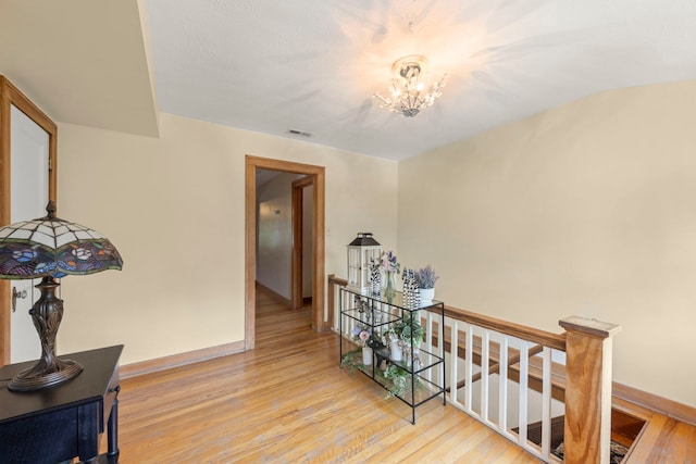 hall featuring light hardwood / wood-style floors and a chandelier