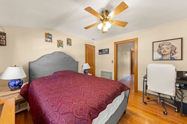 bedroom with ceiling fan, light wood-type flooring, and lofted ceiling