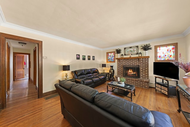 living room with a baseboard radiator, a fireplace, hardwood / wood-style floors, and crown molding