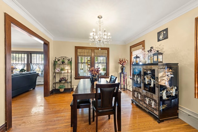 dining area featuring ornamental molding, light wood-type flooring, and plenty of natural light