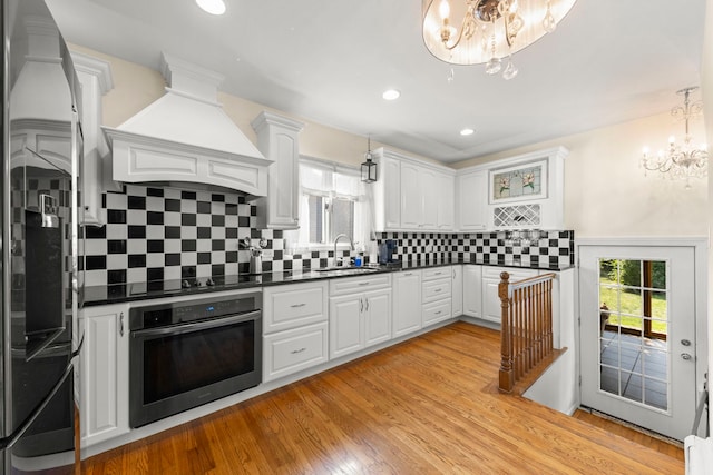 kitchen featuring appliances with stainless steel finishes, decorative backsplash, white cabinetry, and sink