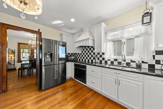 kitchen with light hardwood / wood-style floors, sink, white cabinets, custom exhaust hood, and black appliances