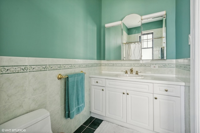 bathroom featuring vanity, walk in shower, tile walls, tile patterned floors, and toilet