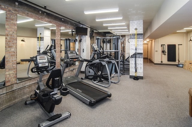 gym with brick wall and carpet flooring