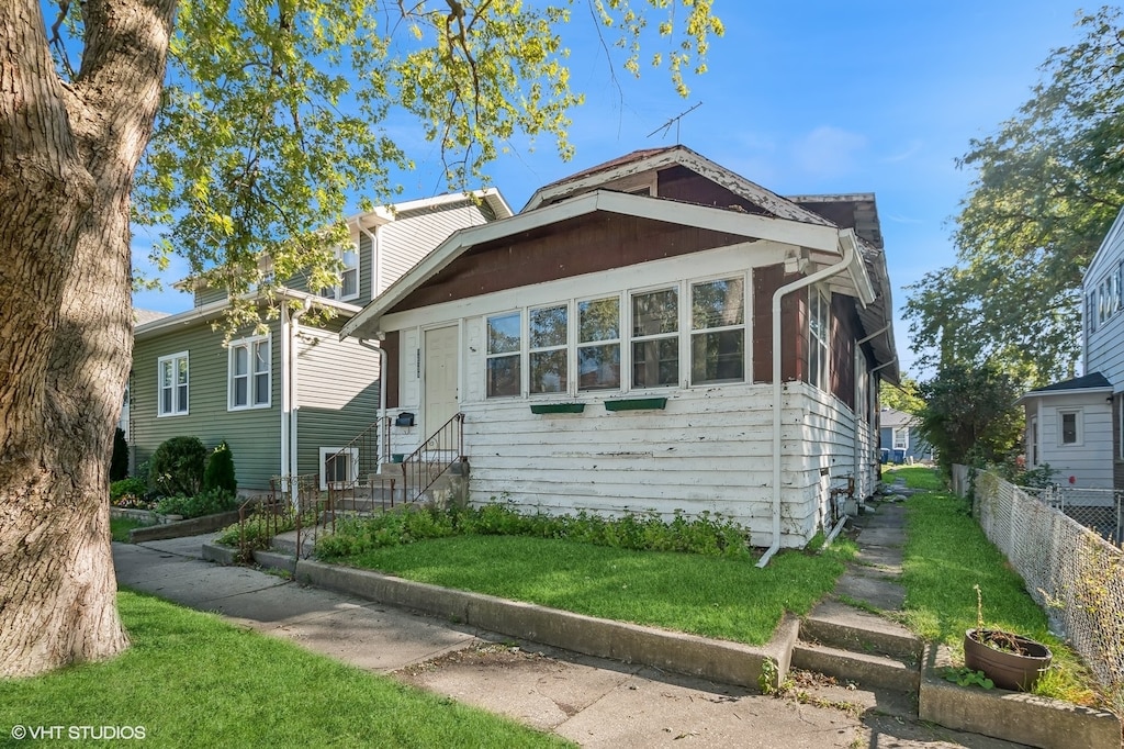 bungalow-style home featuring a front yard