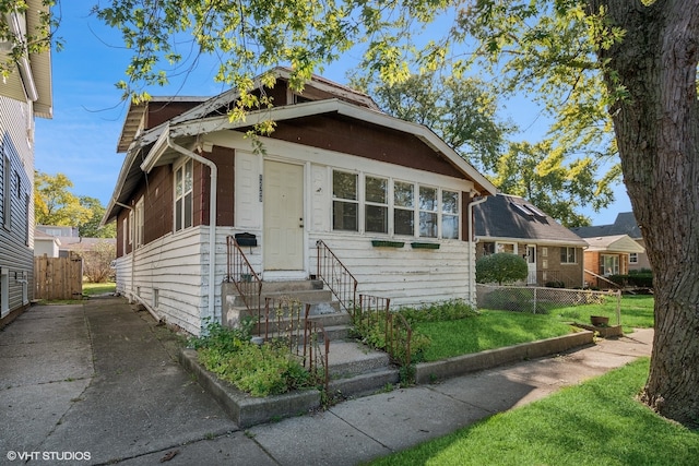 bungalow-style home featuring a front lawn