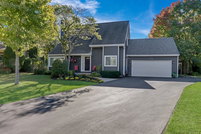 view of front of home with a front yard and a garage