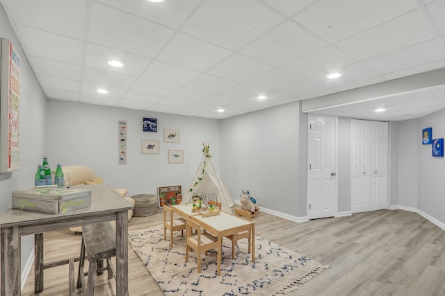 recreation room with light hardwood / wood-style flooring and a drop ceiling