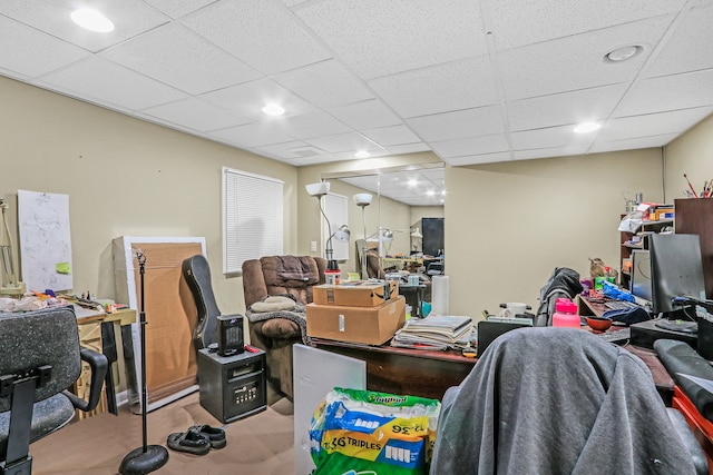 carpeted home office with a paneled ceiling