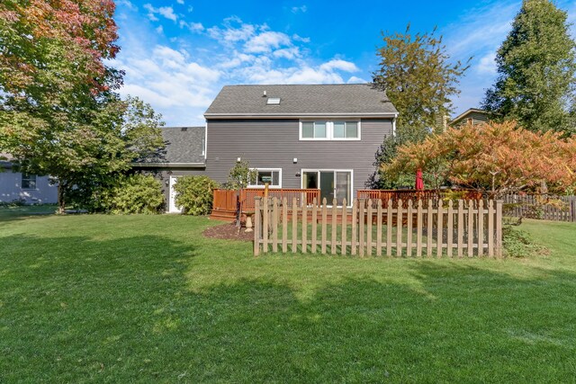 back of house featuring a wooden deck and a lawn