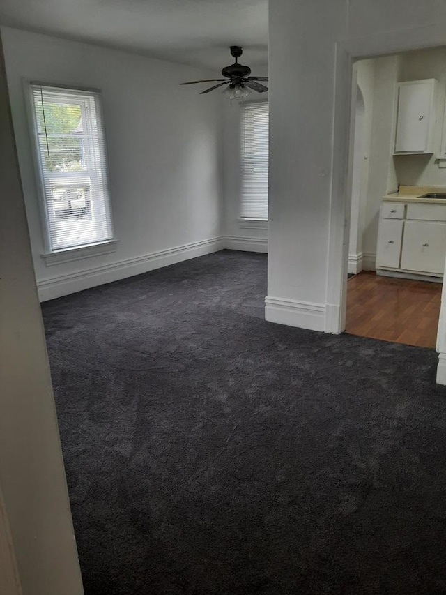 109 E Chamberlin St, Dixon, IL 61021 - unfurnished room with dark carpet, ceiling fan, baseboards, and a sink