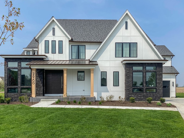 modern farmhouse style home with a garage, a front lawn, and covered porch