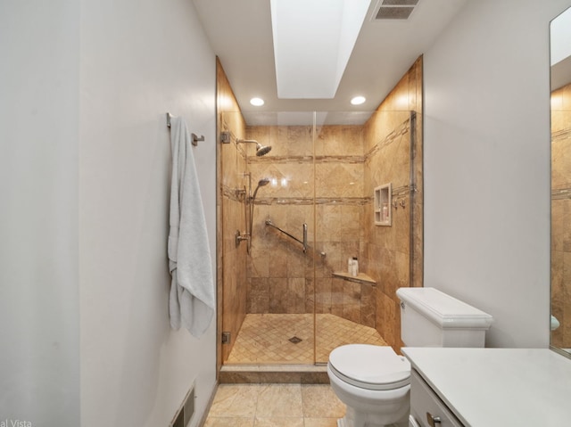 bathroom with toilet, vanity, and a shower with shower door