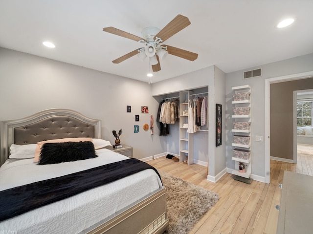 bedroom featuring light hardwood / wood-style flooring, ceiling fan, and a closet