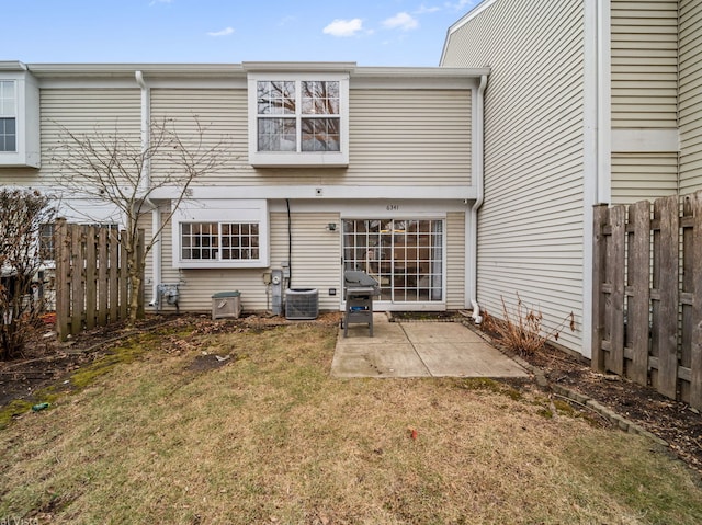 rear view of house with a patio, central AC, and a lawn