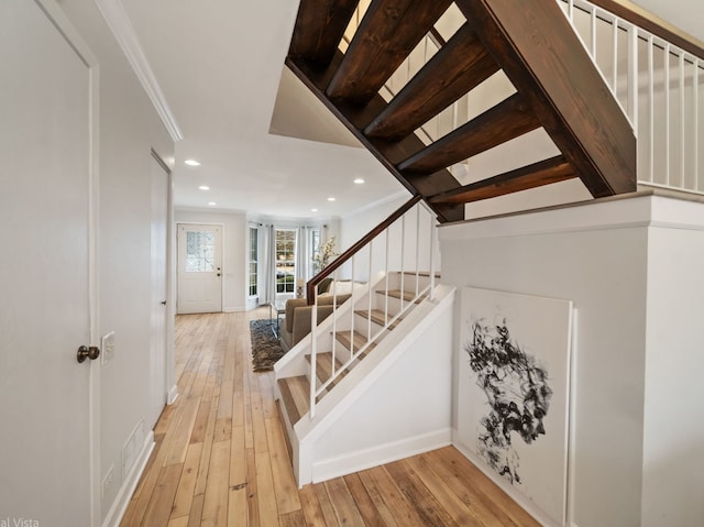 staircase with hardwood / wood-style flooring and ornamental molding