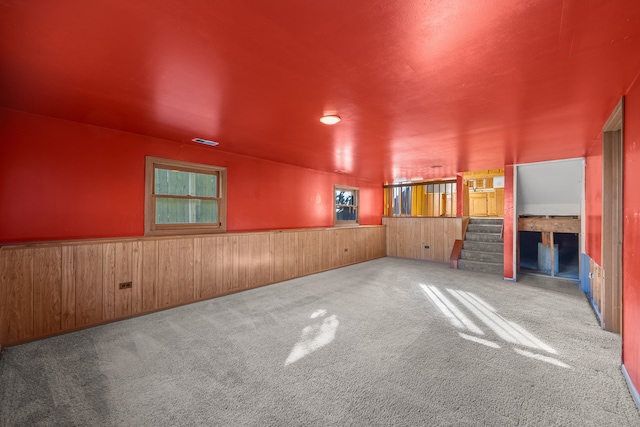 spare room featuring carpet flooring and wooden walls