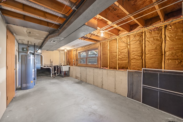 basement featuring gas water heater and sink