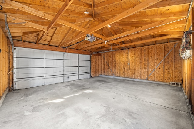 garage with a garage door opener and wooden walls