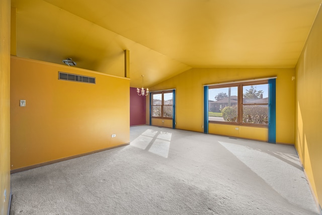 carpeted empty room featuring vaulted ceiling and an inviting chandelier