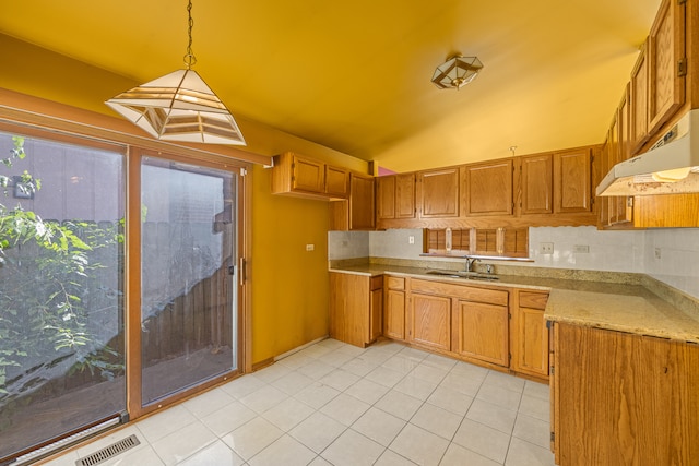 kitchen featuring light tile patterned floors, pendant lighting, lofted ceiling, and sink